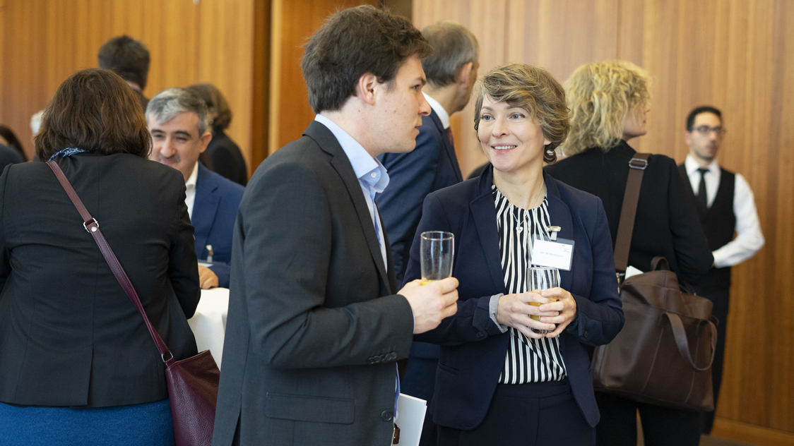 Frauen und Männer stehen an Stehtischen und unterhalten sich. (Quelle: © Annalena Sippl) Frauen und Männer stehen an Stehtischen und unterhalten sich.