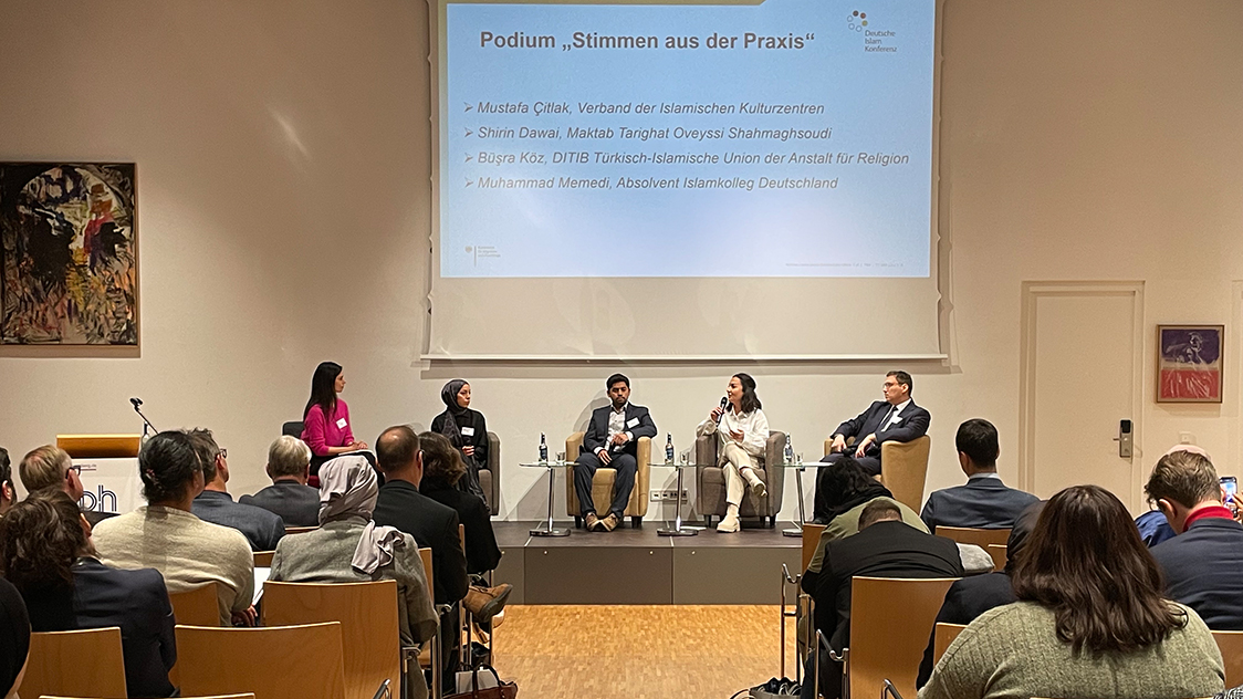 Drei Frauen und zwei Männer sitzen auf einer Bühne vor einem Publikum. (Quelle: BAMF) Drei Frauen und zwei Männer sitzen auf einer Bühne vor einem Publikum.