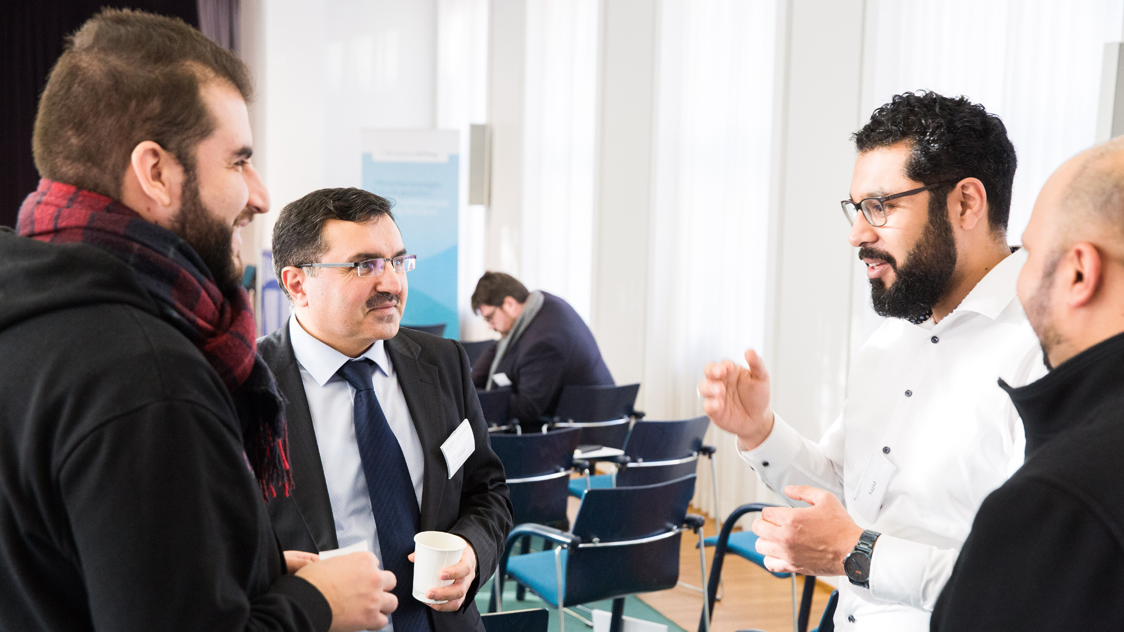 Vier Männer unterhalten sich (Quelle: © Sebastian Pfütze / Bertelsmann Stiftung) Vier Männer unterhalten sich