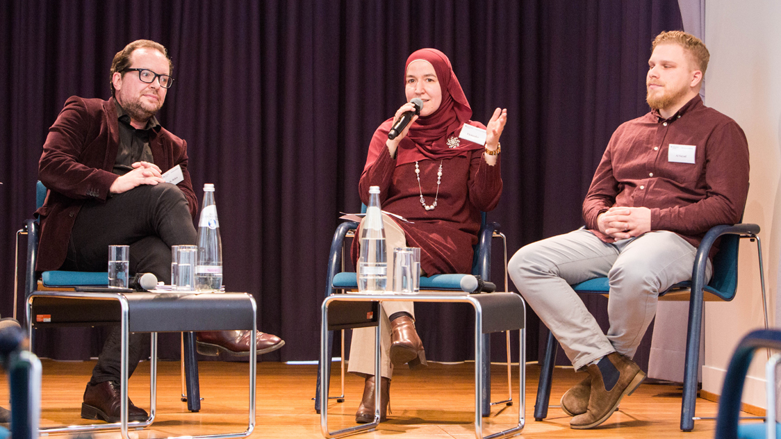 Eine Frau und zwei Männer sitzen auf einer Bühne (Quelle: © Sebastian Pfütze / Bertelsmann Stiftung) Eine Frau und zwei Männer sitzen auf einer Bühne