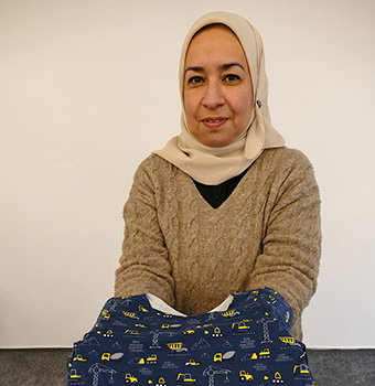 Eine Frau hält ein Stück Stoff in der Hand. (Quelle: Stop press & public/Helmut Stapel) Eine Frau hält ein Stück Stoff in der Hand.