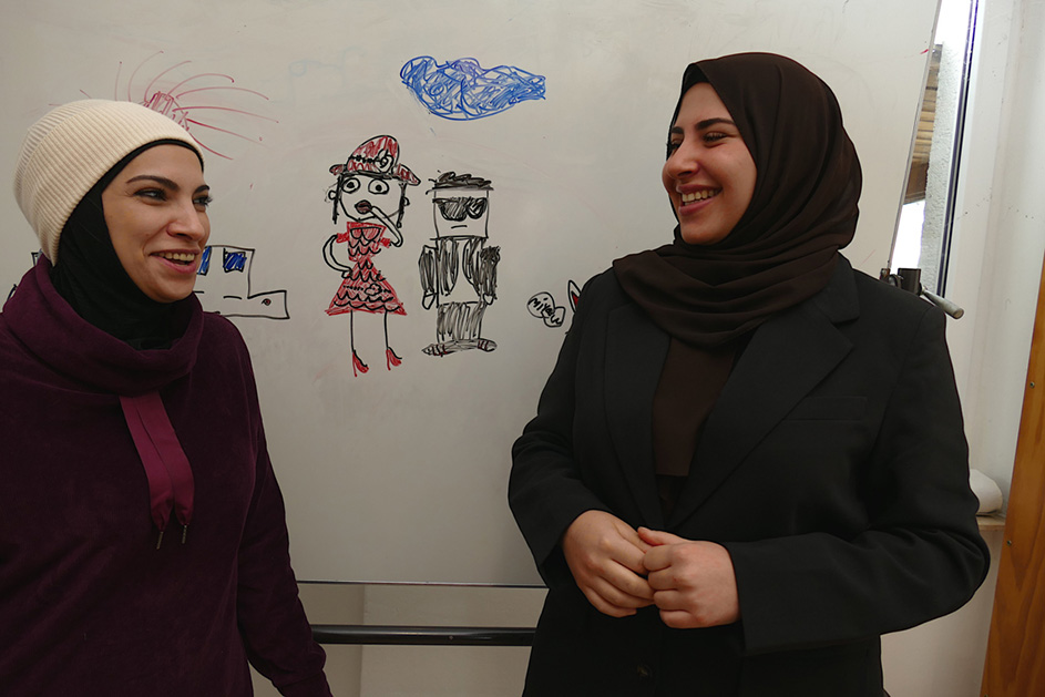 Zwei Frauen stehen vor einer Tafel und lachen. (Quelle: Stop press & public/Helmut Stapel) Zwei Frauen stehen vor einer Tafel und lachen.