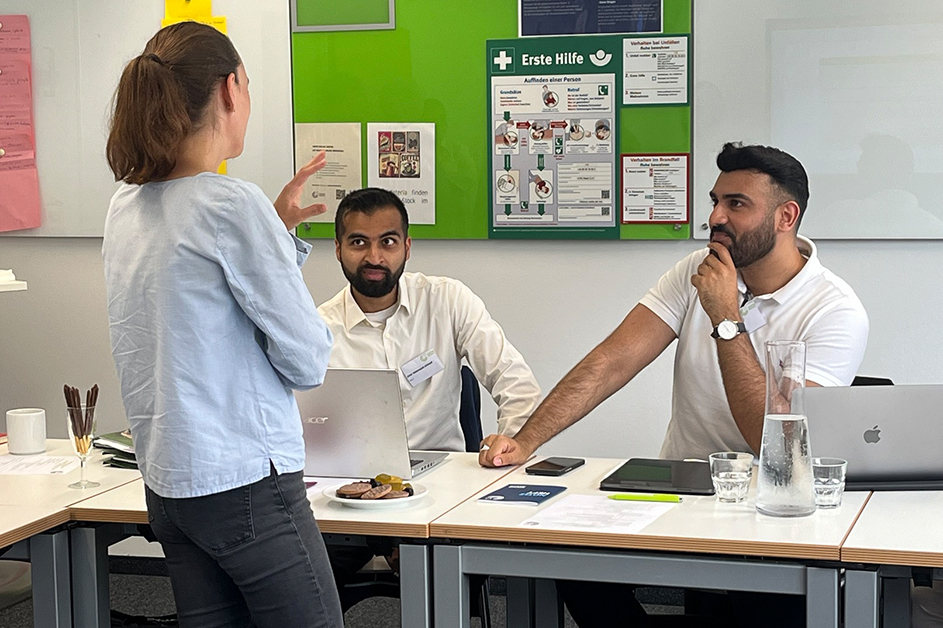 Eine Frau unterhält sich mit zwei Männern (Quelle: © Andrea Beck) Eine Frau unterhält sich mit zwei Männern