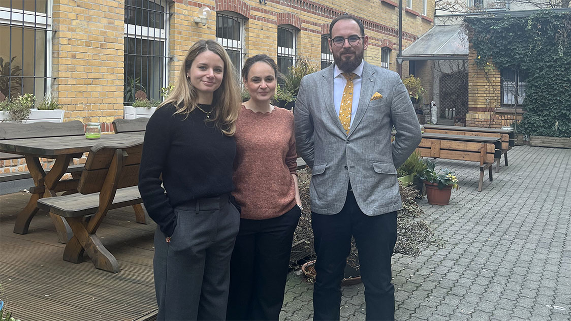 Zwei Frauen und ein Mann stehen vor einem Haus. (Quelle: Milena Jovanovic) Zwei Frauen und ein Mann stehen vor einem Haus.