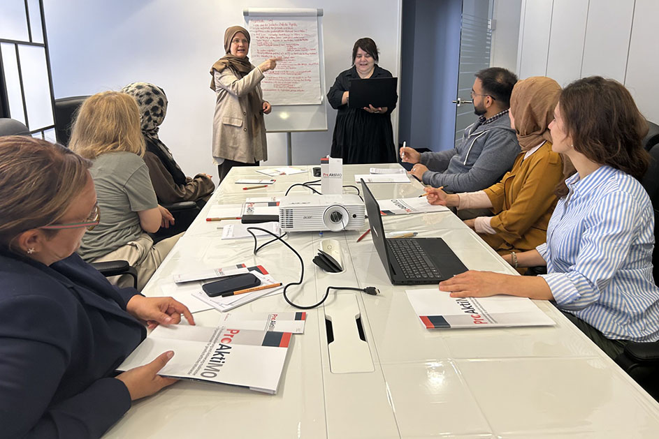 Fünf Frauen und ein Mann sitzen an einem Tisch. Zwei Frauen stehen am Kopf des Tisches. (Quelle: Sozialdienst muslimischer Frauen e.V.) Fünf Frauen und ein Mann sitzen an einem Tisch. Zwei Frauen stehen am Kopf des Tisches.