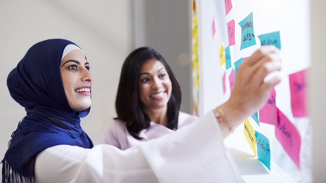Zwei Frauen stehen vor einer Tafel (Quelle: © iStock | Tempura) Zwei Frauen stehen vor einer Tafel