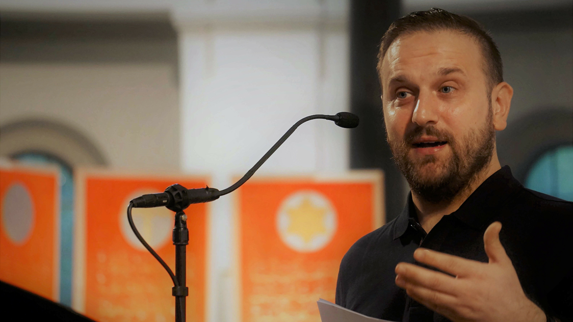 Ein Mann steht vor einem Mikrophon (Quelle: privat) Ein Mann steht vor einem Mikrophon