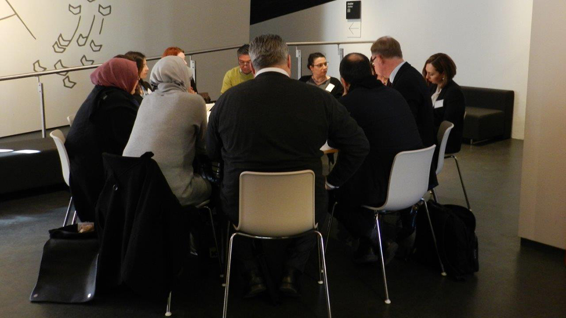 Personen sitzen um einen Tisch. (Quelle: BMI) Personen sitzen um einen Tisch.