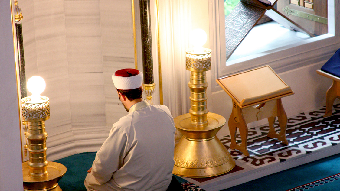 Ein Mann kniet vor einem Altar. (Quelle: Katy Otto) Ein Mann kniet vor einem Altar.