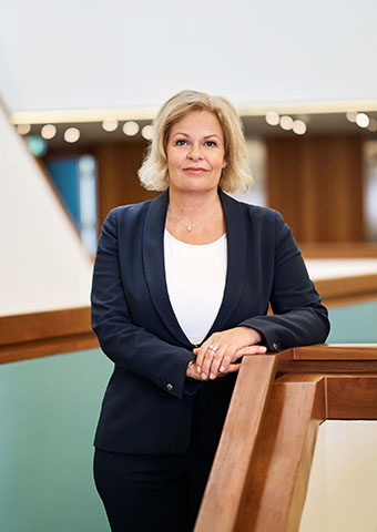 Eine Frau steht an einem Treppenlauf (Quelle:  Bundesfoto | Christina Czybik) Eine Frau steht an einem Treppenlauf